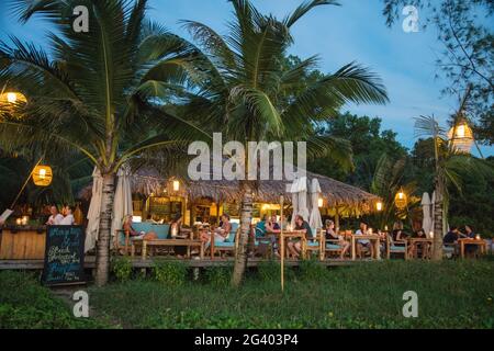 Menschen, die im Restaurant und in der Bar des Mango Bay Resort am Ong lang Beach in der Abenddämmerung, Ong lang, Phu Quoc Island, Kien Giang, Vietnam, Wie Stockfoto