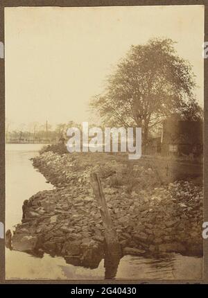 Blick auf ein Ufer mit Gebäuden an der Amstel. Teil des Albums mit Bildern von Amsterdam und Umgebung. Stockfoto