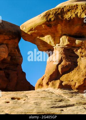 Eine Lücke zwischen zwei Sandstein-Hoodoos, die ein kleines Fenster zum blauen Himmel bilden, im Devil’s Garden, Escalante, Utah, USA Stockfoto