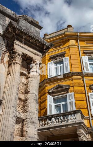 Kontrast zwischen Säulen des alten römischen Bogens der Sergii und Neubau, Pula, Istrien, Kroatien, Europa Stockfoto