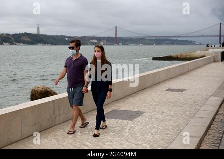 Lissabon, Portugal. Juni 2021. Menschen mit Gesichtsmasken wandern am 18. Juni 2021 in der Nähe des Flusses Tejo in der Innenstadt von Lissabon, Portugal. Die portugiesische Regierung hat am Donnerstag beschlossen, die Verbreitung von Covid-19 in den Großraum Lissabon am Wochenende ab 3 Uhr am Freitag zu verbieten, da die Zahl der Fälle in Teilen des Landes zugenommen hat. Quelle: Pedro Fiuza/ZUMA Wire/Alamy Live News Stockfoto