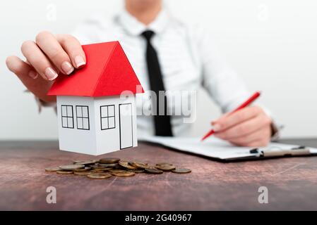 Immobilienmakler und Kunde schütteln Hände nach Abschluss des Vertrages nach über Hausversicherung und Investitionsdarlehen. Hausmodell mit Stockfoto