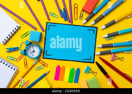 Bannerkonzept Zurück zur Schule Wecker Farbe Kreide Bleistift Apple Notebook Schreibwaren auf Grün Zubehör Draufsicht Flat Lay Schoo Stockfoto