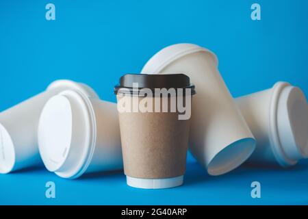 Recycling Brown Paper Coffee Cup Mockup, Take Away Cup für Getränke isoliert auf blauem Hintergrund mit verschütteten White Paper Coffee Cups, Paper Coffee Cup TEM Stockfoto