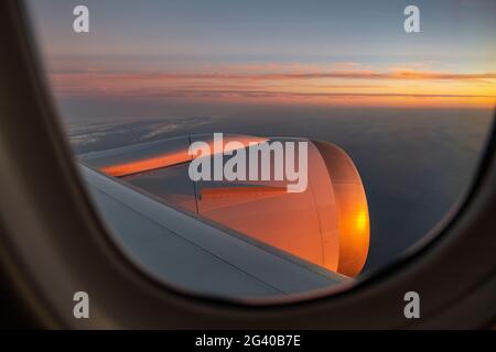 Blick durch das Fenster auf dem Flugzeug des Air Tahiti Nui Boeing 787 Dreamliner bei Sonnenuntergang auf dem Flug vom Los Angeles International Airport (LAX) in Stockfoto