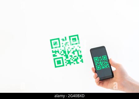 Halten Sie ein Smartphone in der Hand, und scannen Sie den qr-Code, um eine Zahlung zu tätigen Stockfoto
