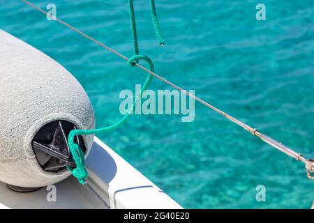 Segelbootsfender auf dem Yachtdeck, türkisblauer Meerwasserhintergrund, Segelboot-Bumber Nahaufnahme, Sommerkreuzfahrt in der Ägäis, Griechenland, Kopierraum, Stockfoto