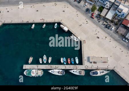 Kykladen Griechische Insel Hafen Marina Luftdrohne Draufsicht. Serifos Island, Griechenland, traditionelle Fischerboote und Yachten, die am Hafendock festgemacht sind, ruhig Stockfoto