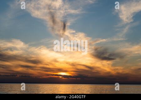 Sonnenuntergang Himmel an der Küste. Goldene Stunde. Himmel und Wolken. Federwolke. Die Sonne ging unter den Horizont. Abendhimmel im Hintergrund. Landschaft bei Sonnenaufgang. Stockfoto