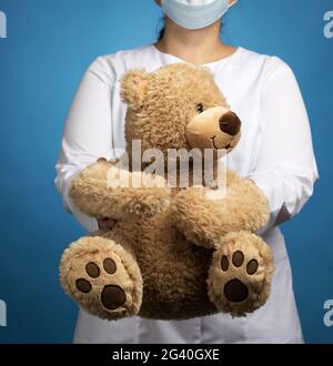 Ärztin Kinderärztin hält einen braunen Teddybär Stockfoto