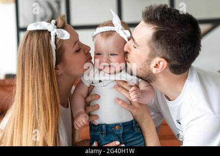 Ein Elternteil von Mutter und Vater küsst ihr kleines Baby Stockfoto