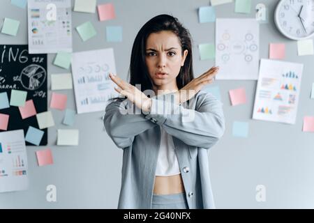 Ich sagte: Nein! Eine wütende Frau zeigt ihre gekreuzten Arme in einem X-Gestenschild und schaut in die Kamera. Stoppschild Stockfoto