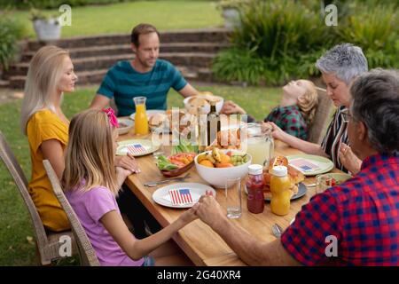 Kaukasische drei-Generationen-Familie hält Hände sagen Gnade vor dem Essen Gemeinsames Essen im Garten Stockfoto