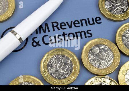 Ein finanzielles Stillleben mit Pfund-Münzen und einem Stift auf einem britischen Steuererklärung. Stockfoto