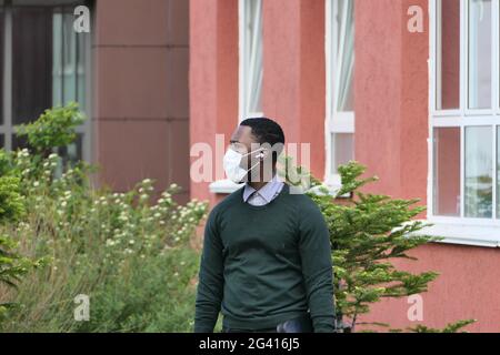 Russland, Nischni Nowgorod, Gagarin Avenue 101 k.2. Ein junger afroamerikanischer Mann auf der Straße, der eine medizinische Maske trägt Stockfoto