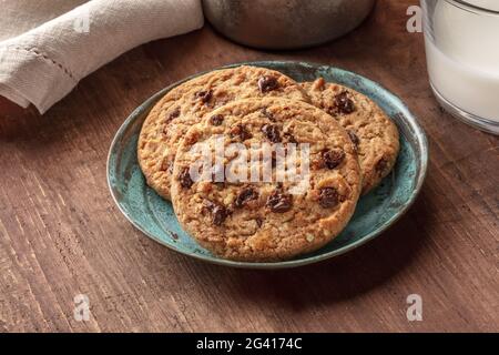 Eine Nahaufnahme von Schokoladenkeksen mit Milch auf einem dunklen Holztisch Stockfoto