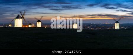 Ein Panoramablick auf die historischen weißen Windmühlen von La Mancha oberhalb der Stadt Campo de Criptana bei Sonnenuntergang Stockfoto