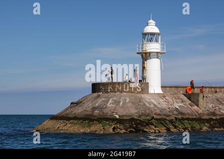 BRIXHAM, DEVON/UK - JULI 28 : Menschen, die am 28. Juli 2012 in der Nähe des Leuchtturms am Hafen von Brixham in Devon angeln. Nicht identifiziertes Peop Stockfoto