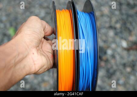 Filament für 3d-Drucker in der Hand gehalten. Material, das dazu verwendet wird, ist Polymilchsäure oder Polylactid, kurz PLA Filament genannt. Stockfoto