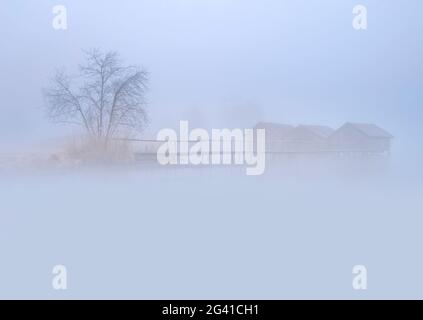 Die drei Fischerhütten von Schlehdorf im Februar im dichten Morgennebel, Schlehdorf, Kochel am See, Oberbayern, Bayern, Deutschland, Europa Stockfoto