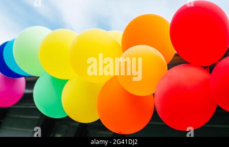 Girlande von bunten Regenbogenballons gegen den Himmel Stockfoto