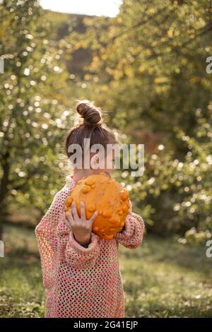 Deformierte hässliche orange Kürbis in einem Kind Hände. Stockfoto