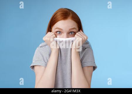 Ihr könnt mich nicht sehen. Dumm niedlich junge Teenager Rotschopf Mädchen versteckt Gesicht ziehen T-Shirt Kopf gucken aufgeregt überrascht Kamera Stockfoto