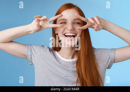 Glücklich fröhlich sorglos kaukasisch rothaarige Mädchen Ingwer lange Haare mit Spaß ausdrücken Glück Freude freundlich Haltung zeigen Frieden vi Stockfoto