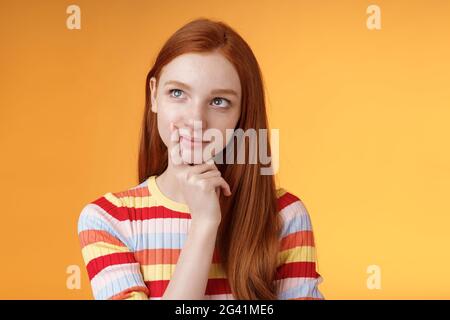 Kreativ nachdenklich junge smart Rotschopf weiblich Student Denken Ideen Projekt Look oben links Ecke verträumt berühren Lip Ponderi Stockfoto