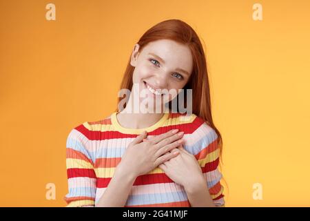 Erfreut zärtlich weiblich gut aussehende Rotschopf Frau erhalten Kompliment Geständnis Berührung Herz fühlen Wärme liebster Moment lächelnd Stockfoto