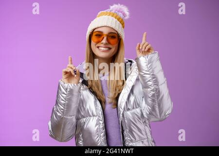 Fröhlich energetisch unterhalten nette blonde Frau Spaß haben Urlaub verschneiten Bergtour tragen Sonnenbrille Silber Jacke gewinnen Stockfoto