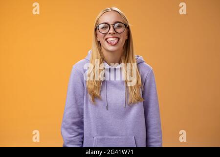 Lustige charmante weibliche Programmierer mit Spaß Show Zunge Narr um Mitarbeiter während der Mittagspause lächelnd breit lachend im Schnitt Stockfoto