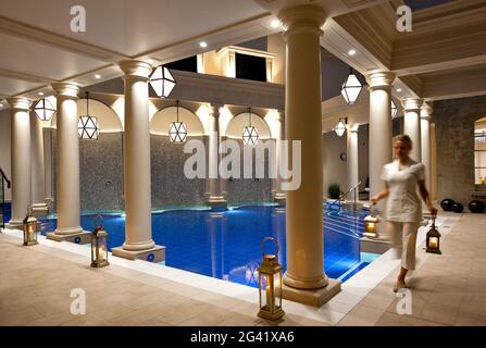 Abendaufnahme des Spa-Therapeuten, der Lampen in einem Pool-Raum trägt. Bath, Großbritannien Stockfoto