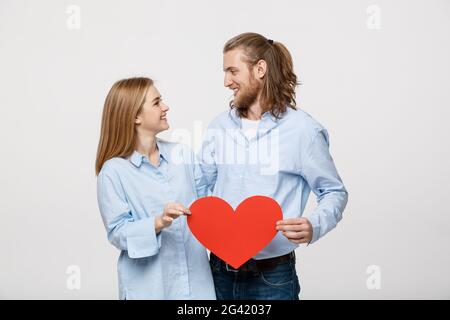Porträt der jungen glückliches Paar in der Liebe halten roten Herz aus Papier. Stockfoto