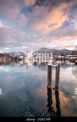 Blick über den winterlichen Tegernsee auf das Dorf Rottach-Egern mit der Kirche Sankt Laurentius, Bayern, Deutschland. Stockfoto