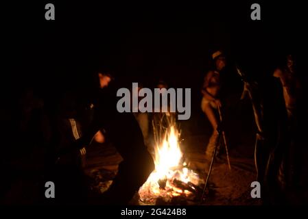 Bushmen Naro Tribe genießen ihren traditionellen Tanz um ein Feuer in der Nacht. Botswana ist die Heimat von etwa 63,500 San, was etwa 2.8 % der Bevölkerung des Landes ausmacht und damit das Land mit der höchsten Bevölkerung von San ist. Die San-Völker (auch Saan) oder Buschmänner sind Mitglieder verschiedener Khoe-, Tuu- oder Kxʼa-sprechender indigener Jäger- und Sammlergruppen, die die ersten Nationen des südlichen Afrikas sind. Botswana. Stockfoto