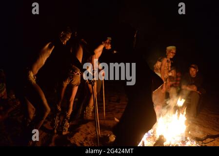 Bushmen Naro Tribe genießen ihren traditionellen Tanz um ein Feuer in der Nacht. Botswana ist die Heimat von etwa 63,500 San, was etwa 2.8 % der Bevölkerung des Landes ausmacht und damit das Land mit der höchsten Bevölkerung von San ist. Die San-Völker (auch Saan) oder Buschmänner sind Mitglieder verschiedener Khoe-, Tuu- oder Kxʼa-sprechender indigener Jäger- und Sammlergruppen, die die ersten Nationen des südlichen Afrikas sind. Botswana. Stockfoto