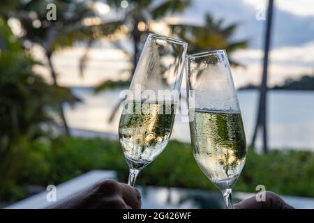 Toasten mit zwei Gläsern Champagner in einer Villa im Six Senses Fiji Resort, Malolo Island, Mamanuca Group, Fidschi-Inseln, Südpazifik Stockfoto