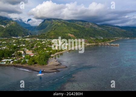 Luftaufnahme des Auslegerkanus mit Segeln am Strand mit Küste und Bergen dahinter, Nuuroa, Tahiti, Windward Islands, Französisch-Polynesien, Süden Stockfoto