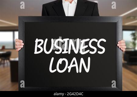 Geschäftsmann hält ein großes Schild mit der Nachricht Business Loan. Stockfoto