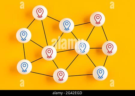 Kugeln mit Positionsnadelsymbolen, die miteinander verknüpft sind und ein Netzwerk darstellen. GPS-Standortnavigationskonzept. Stockfoto