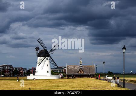 Lytham, Großbritannien. Juni 2021. Starkes Sonnenlicht sticht die Windmühle auf Lytham Green gegen dunkle Wolken aus Quelle: PN News/Alamy Live News Stockfoto