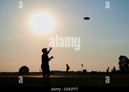 Berlin, Deutschland. Juni 2021. Zwei Männer spielen Frisbee in der allabendlichen Sonne auf dem Tempelhofer Feld bei sehr warmen Temperaturen. Quelle: Annette Riedl/dpa/Alamy Live News Stockfoto