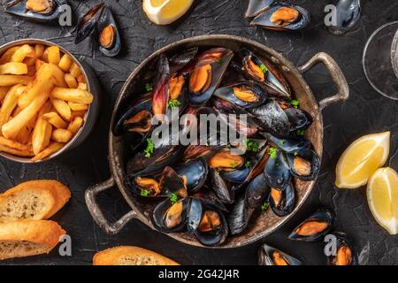 Muscheln mit Kartoffeln, Zitronen und geröstetem Brot, Top Shot Stockfoto