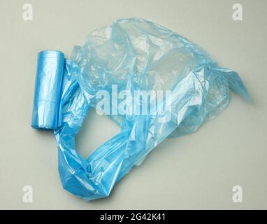 Verdrehte blaue Plastiktüten für bin auf grauem Hintergrund Stockfoto