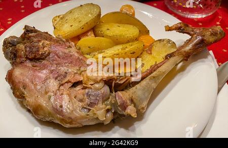 Nahaufnahme von leckerem Lammfleisch, das auf dem Grill zubereitet wird und im eleganten Restaurant serviert wird. Eine leckere Ziege auf einem Grill mit Kartoffeln und Karotten auf dem Teller. Grill Stockfoto