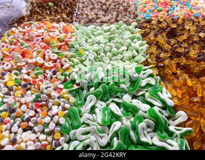 Verschiedene leckere Süßigkeiten und Gelees als Hintergrund. Viele bunte Gelee Süßigkeiten Bonbon Geschmack. Draufsicht. Stockfoto