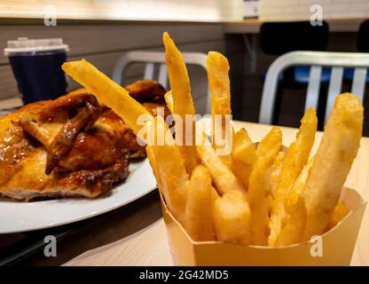 Restaurant mit Pommes frites im Inneren des Burger-Ladens. Nahaufnahme von leckeren frittierten Kartoffeln Snacks. Fast Food und ungesunde Ernährung Konzept Stockfoto