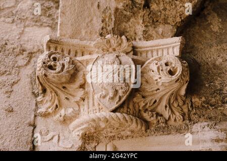 Die Spitze einer Basreliefsäule mit einem Schildmuster, das einen Drachen zeigt, in der Altstadt von Kotor, Montenegro. Stockfoto