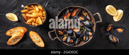 Miesmuscheln mit Zitrone, Pommes und geröstetem Brot Stockfoto